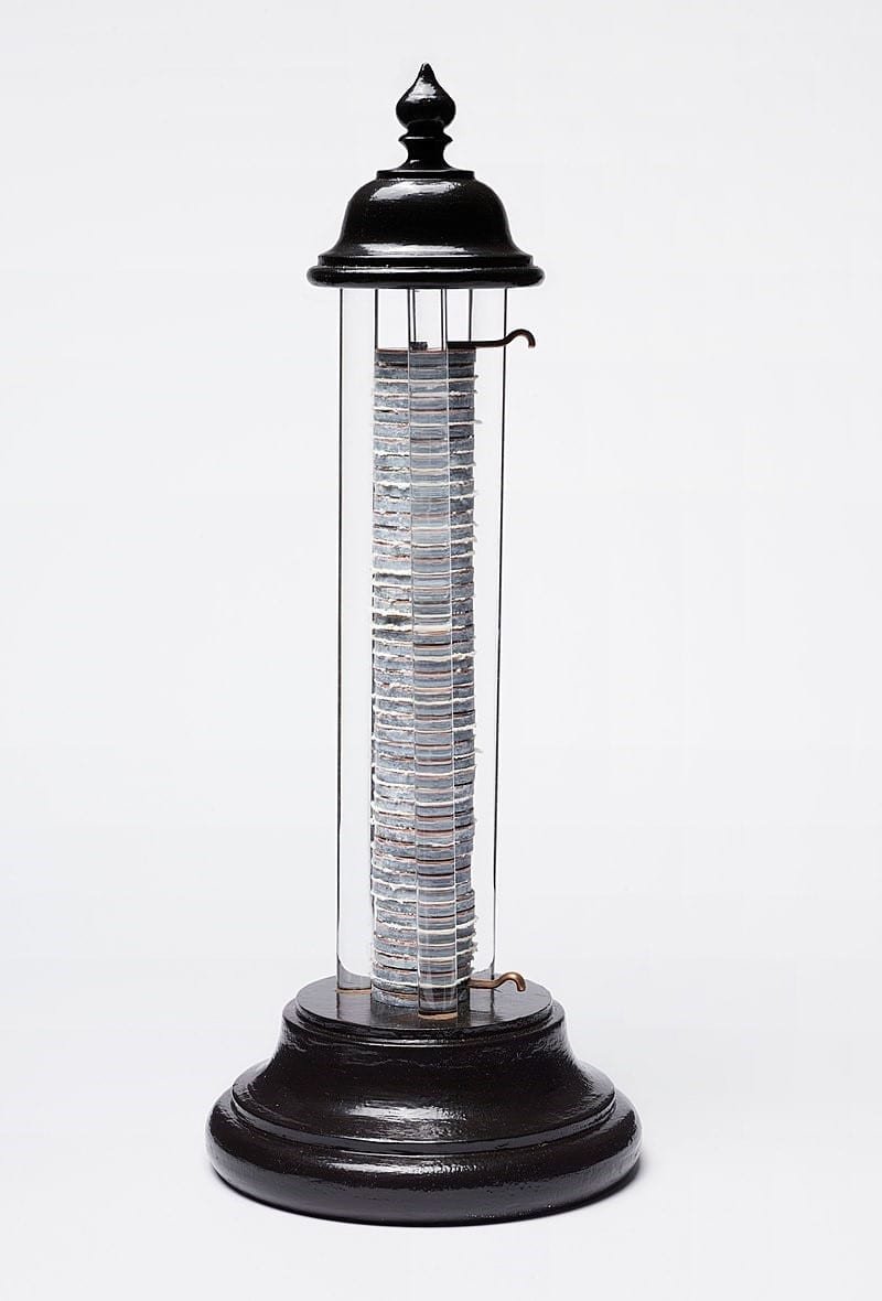Reproducción de la pila voltaica, la primera batería eléctrica inventada por Alessandro Volta en 1800. La base y la parte superior son de madera. Entre la base y la parte superior descansa un montón o pila de 46 celdas de cobre-zinc. Los electrodos utilizados para transferir la corriente eléctrica se encuentran en las celdas superior e inferior. Se coloca tela entre cada celda. La estructura vertical está soportada por cuatro pasadores