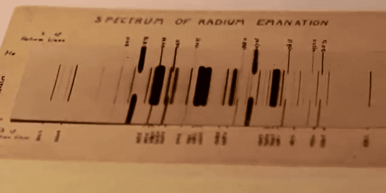 El espectro de emisión de radón, fotografiado por Ernest Rutherford en 1908. Los números al lado del espectro son longitudes de onda. El espectro medio es de emanación de radio (radón), mientras que los dos exteriores son de helio (añadido para calibrar las longitudes de onda).
