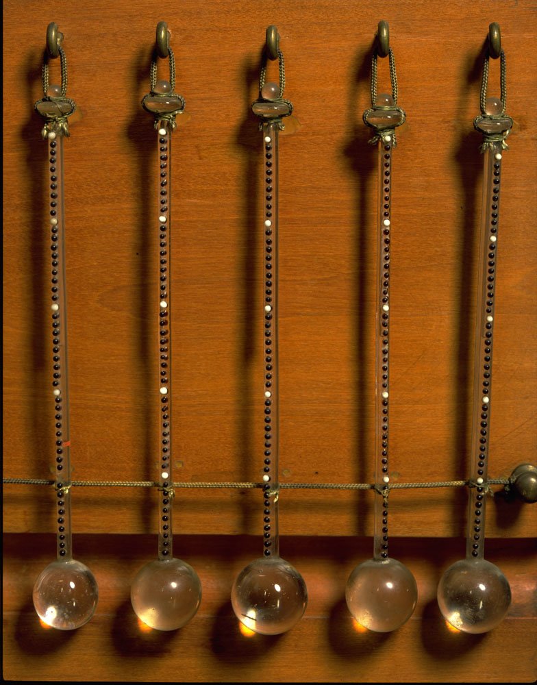 Termómetros de 50 grados de mediados del siglo XVII expuestos en el Museo Galileo con puntos negros que representan grados simples y blancos que representan incrementos de 10 grados; usados para medir las temperaturas atmosféricas.