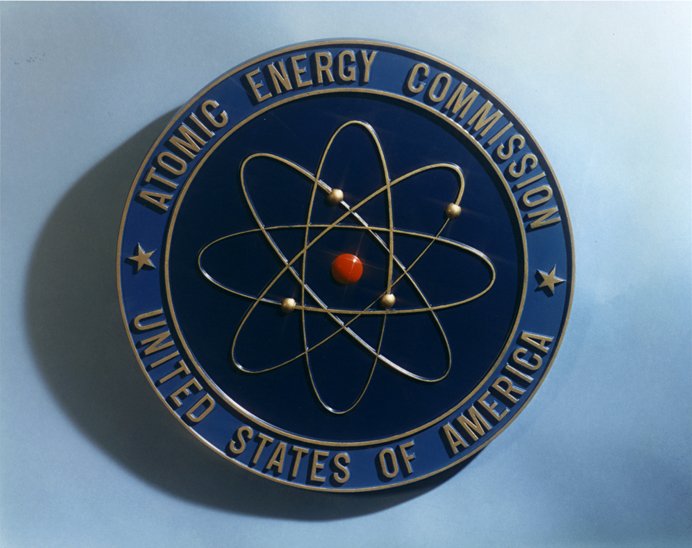 Escudo de la Comisión de Energía Atómica de los Estados Unidos, basado en el modelo atómico de Rutherford