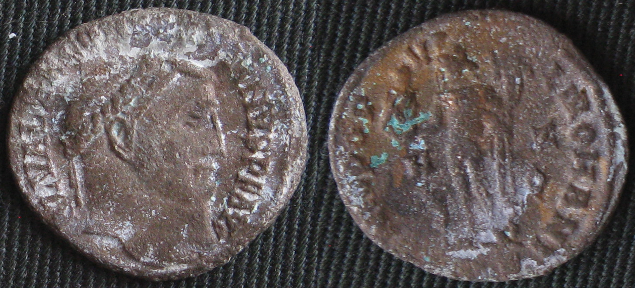 Cristales de carbonato de sodio no identificados (blancos) formados en la misma moneda romana tratada para la enfermedad del bronce. Las masas verdes en el reverso de la moneda son un carbonato de cobre que se formó en la región donde la enfermedad del bronce era más frecuente.