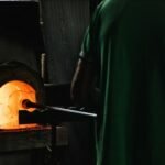 worker blowing glass in workshop